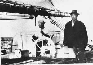Capt. John Clarence at the wheel of the 'Maisie Hassell' and his brother standing Capt. William Benjamin Hassell